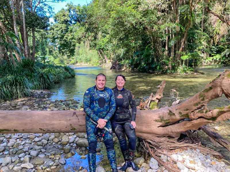 Chris & Matt sitting on a log after the first dip into the cool waters on the River Drift Snorkelling Tour